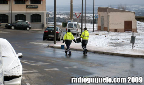 Dos operarios del Ayuntamiento de Guijuelo esparcen sal en una céntrica rotonda