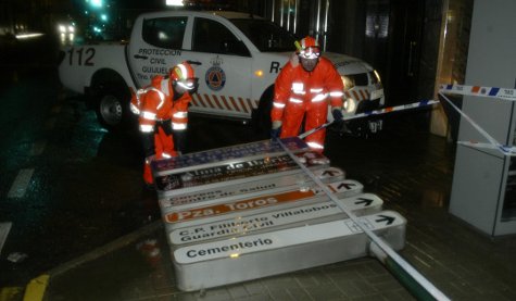 Voluntarios de Protección Civil aseguran un cartel derribado por el viento