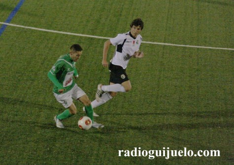 Rubén Peña conduce el balón ante la mirada de un jugador del Burgos C.F.
